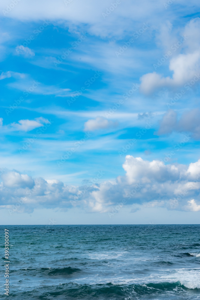 青空に浮かぶ雲とエメラルドグリーンの海の地平線 青空に浮かぶ雲とエメラルドグリーンの海の地平線