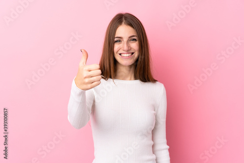 Young woman over isolated pink background with thumbs up because something good has happened