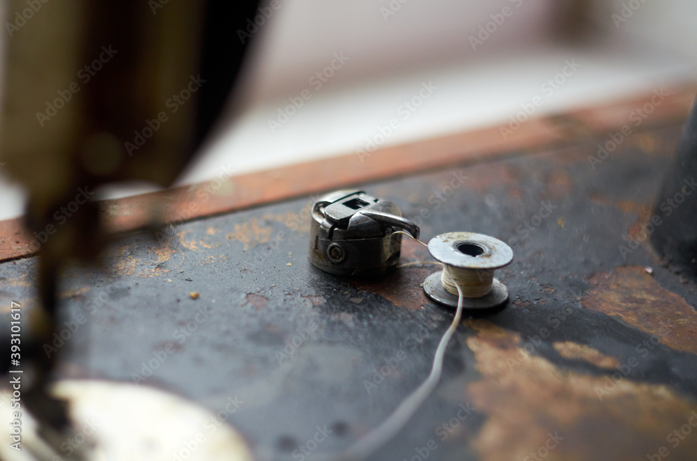 Photo of bobbin and spool with white thread Photo of bobbin and spool with white thread