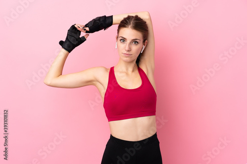 Fototapeta Naklejka Na Ścianę i Meble -  Young sport woman over isolated pink background stretching