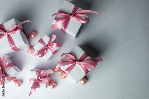 White gifts with pink ribbons. Set of gift box isolated on white background.Christmas gift boxes on white background. Beautiful Christmas background with shiny balls and ribbons in pastel pink color. 