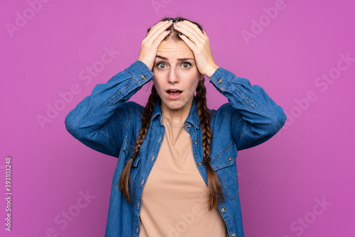 Young woman over isolated purple background with surprise facial expression