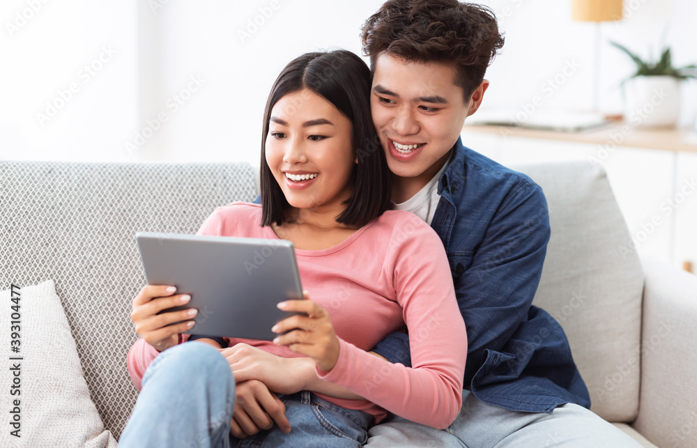 Japanese Spouses Watching Favorite Movie Online Sitting On Couch Indoor Japanese Spouses Watching Favorite Movie Online Sitting On Couch Indoor