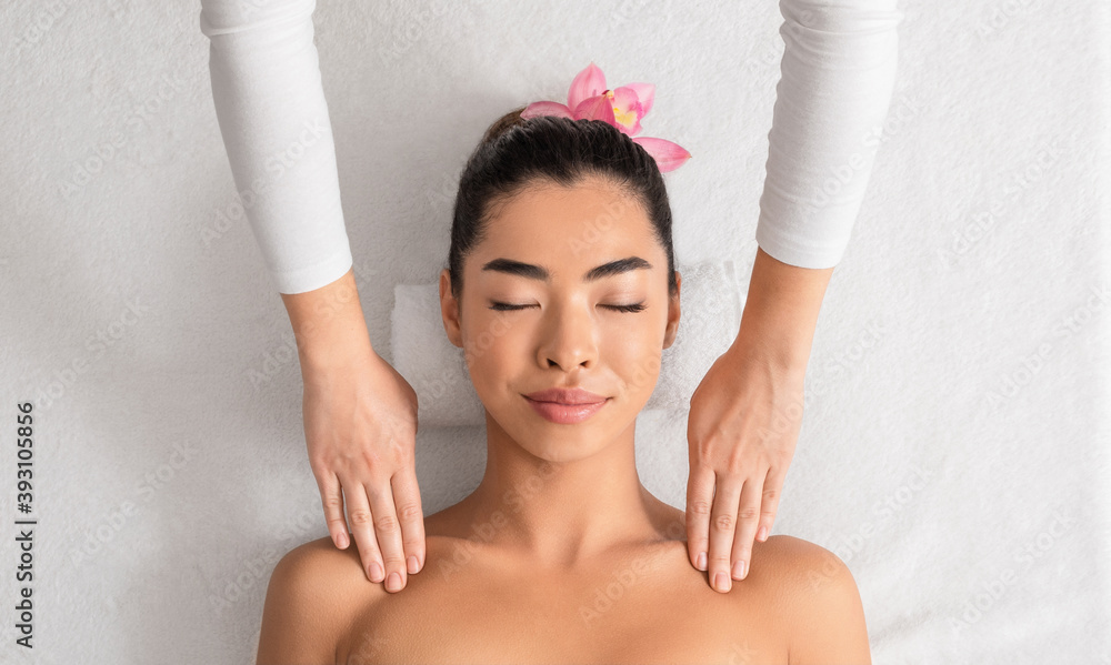 Beautiful asian woman enjoying shoulders massage from masseur at spa Beautiful asian woman enjoying shoulders massage from masseur at spa
