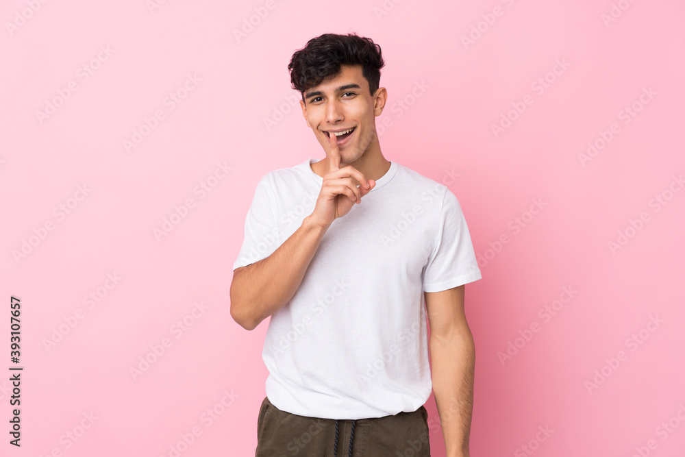 Young Argentinian man over isolated pink background doing silence gesture Young Argentinian man over isolated pink background doing silence gesture