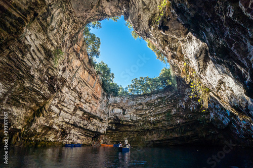 Melissani cave or Melissani lake in Kefalonia Greece. View of the hole of the cave's roof surrounded by trees