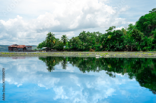 A quiet view of the lake with a reflection of the blue sky on the surface of the water. Beautiful lake landscape photos for backgrounds and wallpapers