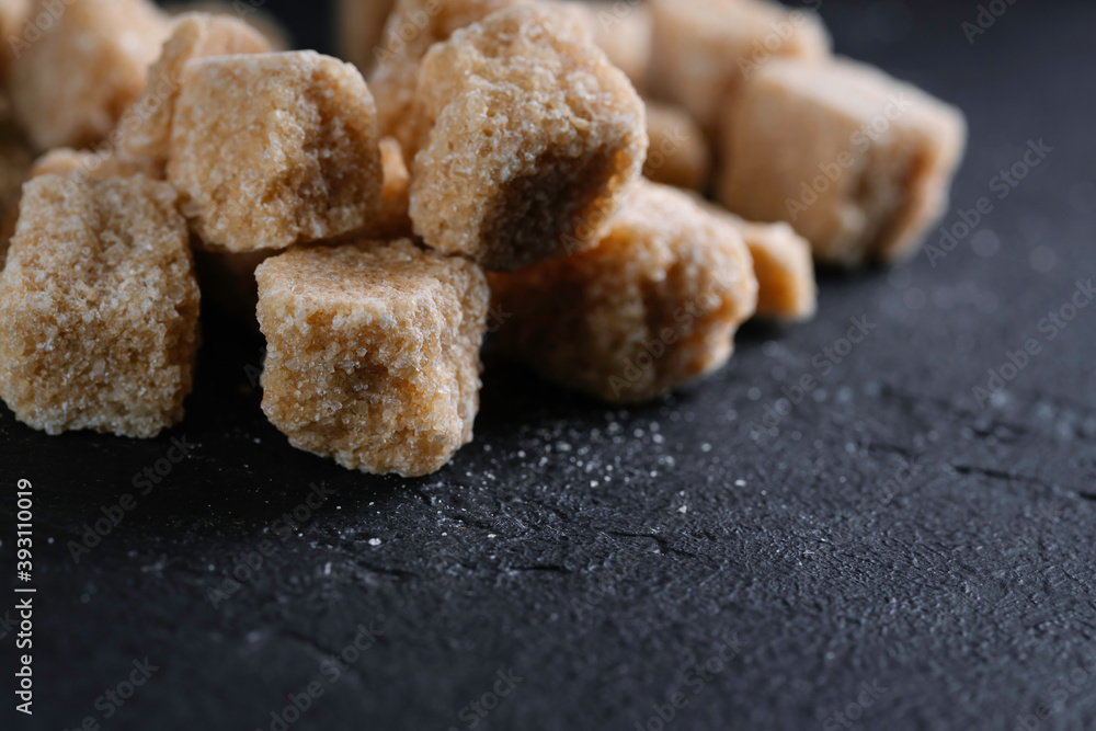 Natural brown sugar cubes on a dark background. Sweet sugar. Natural brown sugar cubes on a dark background. Sweet sugar.