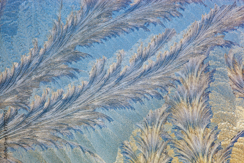 Frost forms in patterns on window glass on a cold winter morning