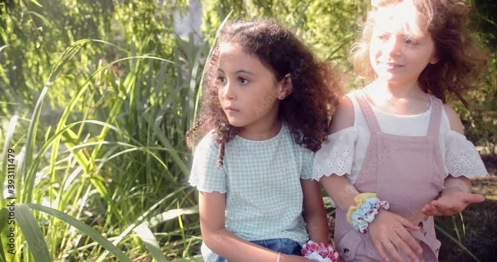 Two little cute girls standing together in a garden Two little cute girls standing together in a garden