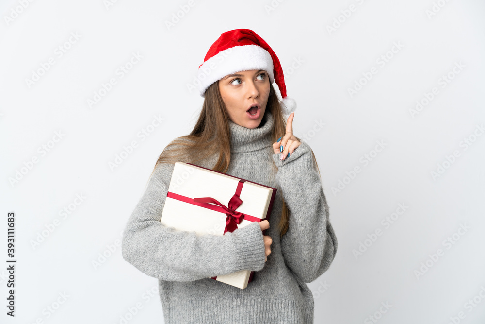Lithianian woman with christmas hat holding presents isolated on white background thinking an idea pointing the finger up Lithianian woman with christmas hat holding presents isolated on white background thinking an idea pointing the finger up
