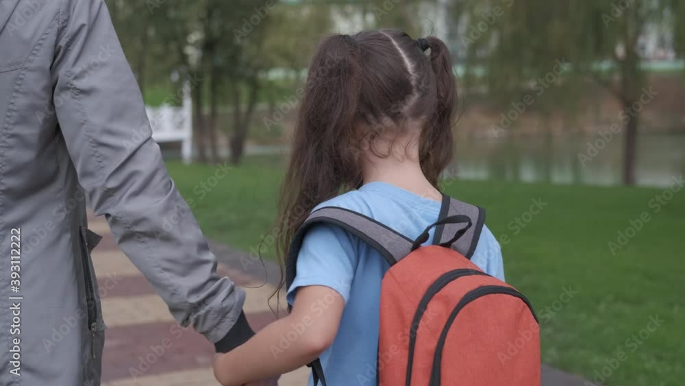 Schoolgirl in a protective mask. Mother with child after school. A schoolgirl in a protective mask goes to school with her mother. Schoolgirl in a protective mask. Mother with child after school. A schoolgirl in a protective mask goes to school with her mother.