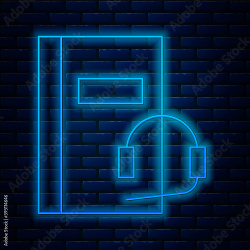 Glowing neon line Audio book icon isolated on brick wall background. Book with headphones. Audio guide sign. Online learning concept. Vector Illustration.