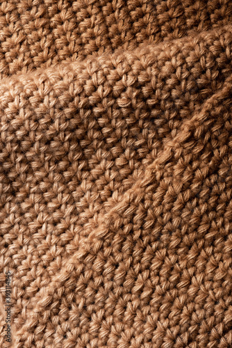 Brown knitted fabric close up. Fabric texture or background