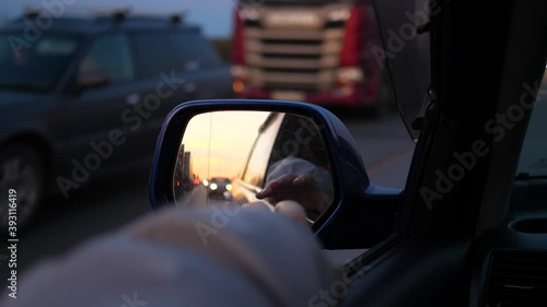 Family trip. The family is driving on the highway. Reflection in the mirror. Sunset time photo