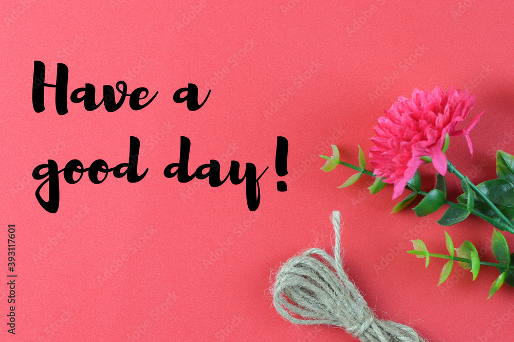Fototapeta premium Top view of flower, rope on a red background written with text HAVE A GOOD DAY!. Motivational concept.
