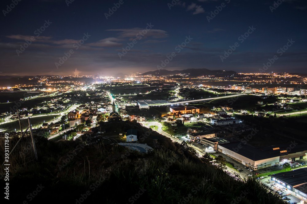 foto nocturna, vista desde lo alto de un barrio de noche. Iluminación de edificios, un puente y carretera.