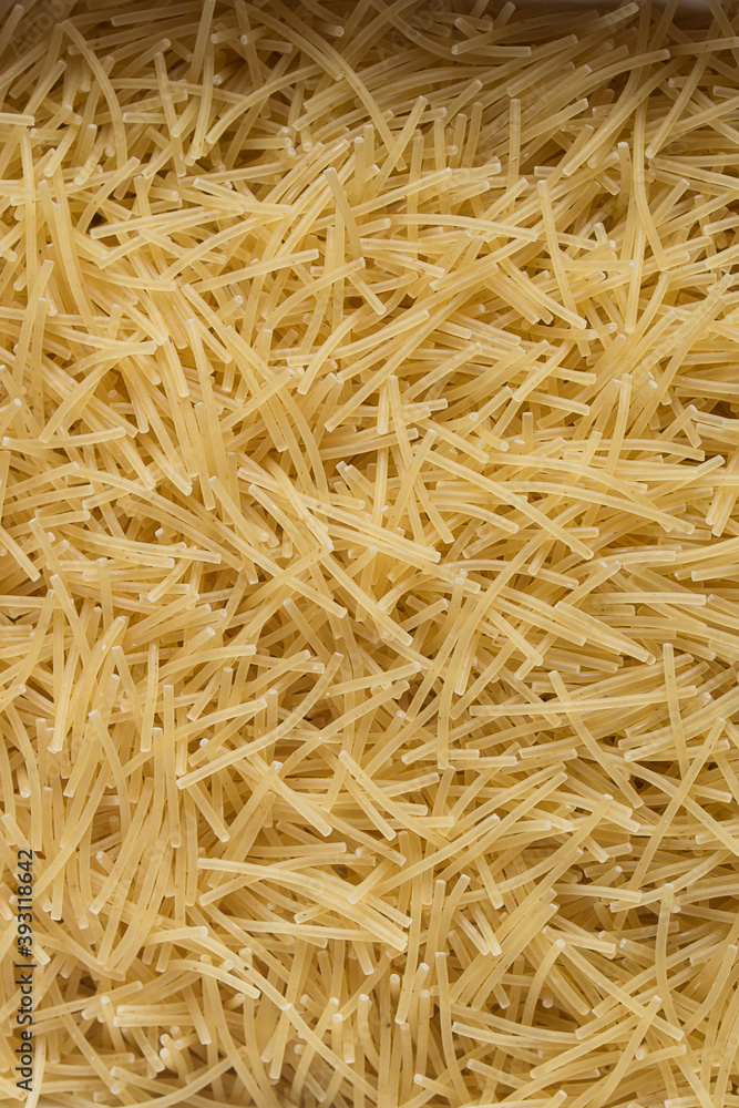 Vertical close-up of a plate full of raw noodle pasta with traces of egg.
. Organic textures as a background. Vegan food. Vertical close-up of a plate full of raw noodle pasta with traces of egg.
. Organic textures as a background. Vegan food.