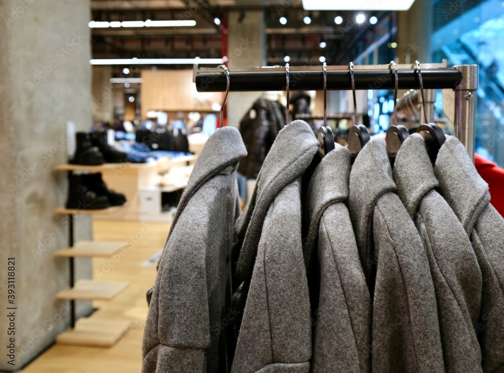 The choice of clothes in the store. Coats of different sizes on a hanger in a clothing store. Women's clothing on a hanger in the mall