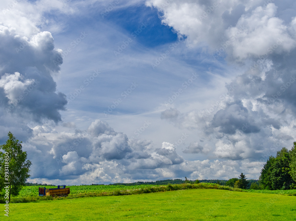 Obraz premium A farmland with beautiful clouded sky above creating some kind of a frame.