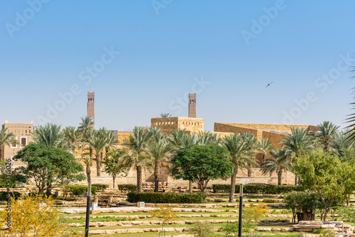 Green date trees growing in the park in the Ruins of Diraiyah, also as Dereyeh and Dariyya, a old town in Riyadh, Saudi Arabia photo