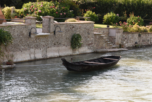 Wooden rowing boat on the Mincio river in Borghetto, Verona (Italy).