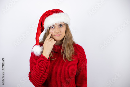 Young pretty blonde woman wearing a red casual sweater and a christmas hat over white background doing money gesture with hands  asking for salary payment  millionaire business