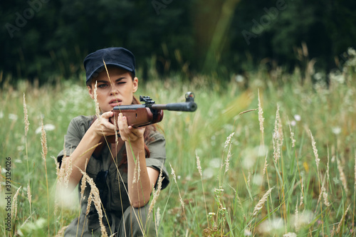 Woman Hunting is sitting on the grass green overalls