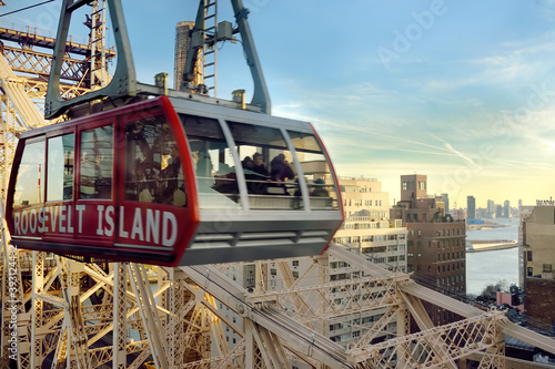 New York, USA - December 24, 2019: Cabin of the famous Roosevelt Island cable car in front of the Ed Coch Queensboro Bridge from Manhattan to Queens in New York. photo