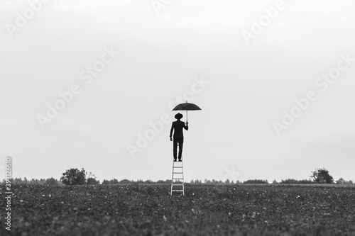 Foto surreal silhouette of a man in a suit with an umbrella standing on the stairs in