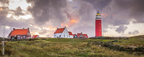 Landscape with scenic view of Lighthouse during sunset with rainy clouds at Waddenisland Texel, North Holland, Netherlands photo