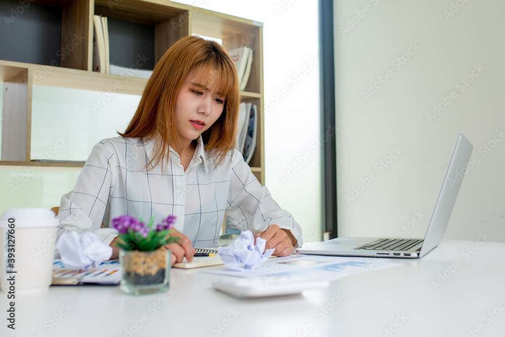 Asian Young Business women stress their job by scrunching up disapproved papers and throwing them in the office, a stress-to-work concept. Asian Young Business women stress their job by scrunching up disapproved papers and throwing them in the office, a stress-to-work concept.