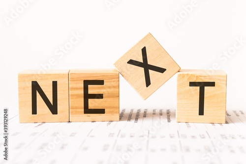 Word next. Wooden small cubes with letters isolated on white background with copy space available.Business Concept image.