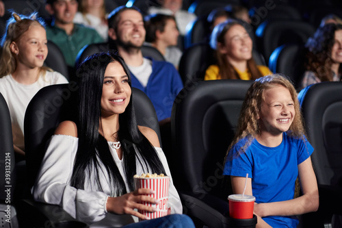 Brunette woman with younger sister in cinema.