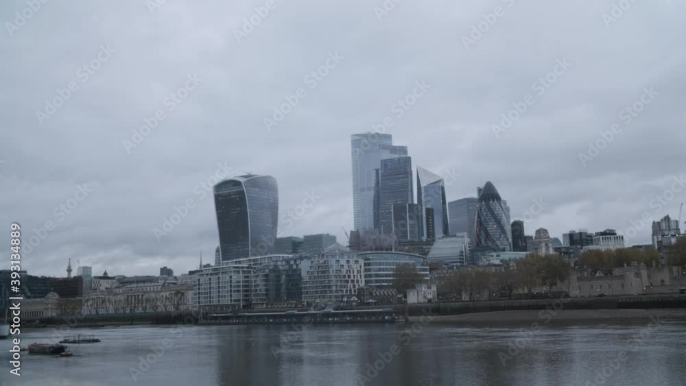 Central London skyscrapers on a cloudy rain day reflected in the Thames river Central London skyscrapers on a cloudy rain day reflected in the Thames river
