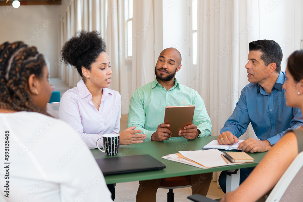 Serious black business woman collaborating and discussing project plans in office workspace. Collaboration, creative, discussion, meeting concept.. Serious black business woman collaborating and discussing project plans in office workspace. Collaboration, creative, discussion, meeting concept..