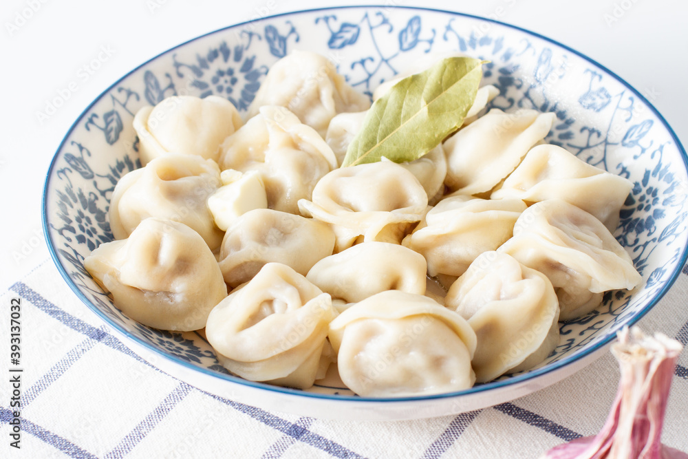 Dumplings in a blue plate on a checkered towel Dumplings in a blue plate on a checkered towel