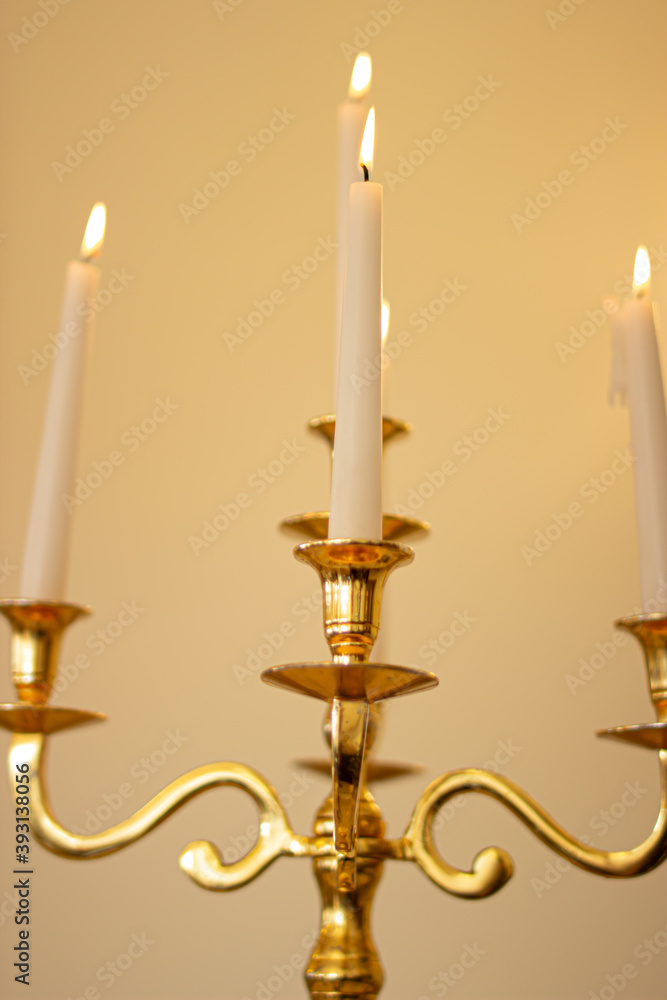 Gold candlestick with lit wax candles close up from below Gold candlestick with lit wax candles close up from below