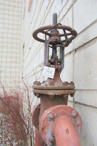 Old damaged and rusty iron oil pipe valve wheel. Metal, pipeline and mechanic concept. An old iron valve on a gas pipe. A valve to cover the pipe with a round handle