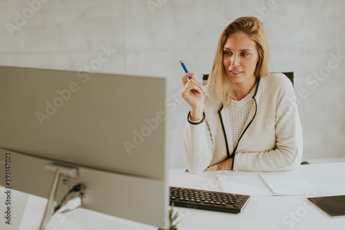 Bbeautiful businesswoman working on laptop in bright modern office photo