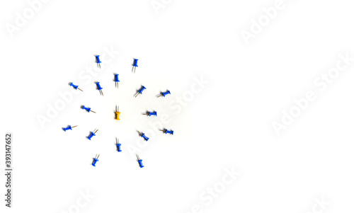 Yellow push pin in the center of the blue push pins with their spike facing yellow. The concept of aggression and attack