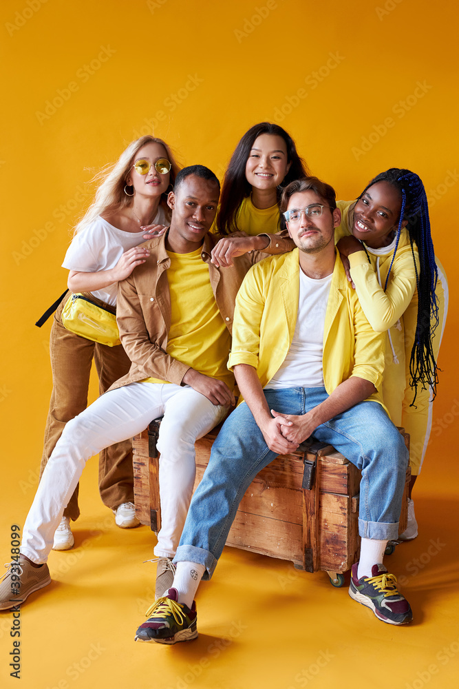 Obraz premium studio shoot of encouraged models of diverse races isolated on yellow background, beautiful guys and ladies happy to be in one group, team, country, friendship concept