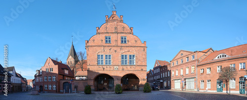 Panorama of the market place in the city of Gadebusch with the medieval town hall in red brick architecture, church tower and houses, blue sky with copy space, Mecklenburg-Western Pomerania, Germany