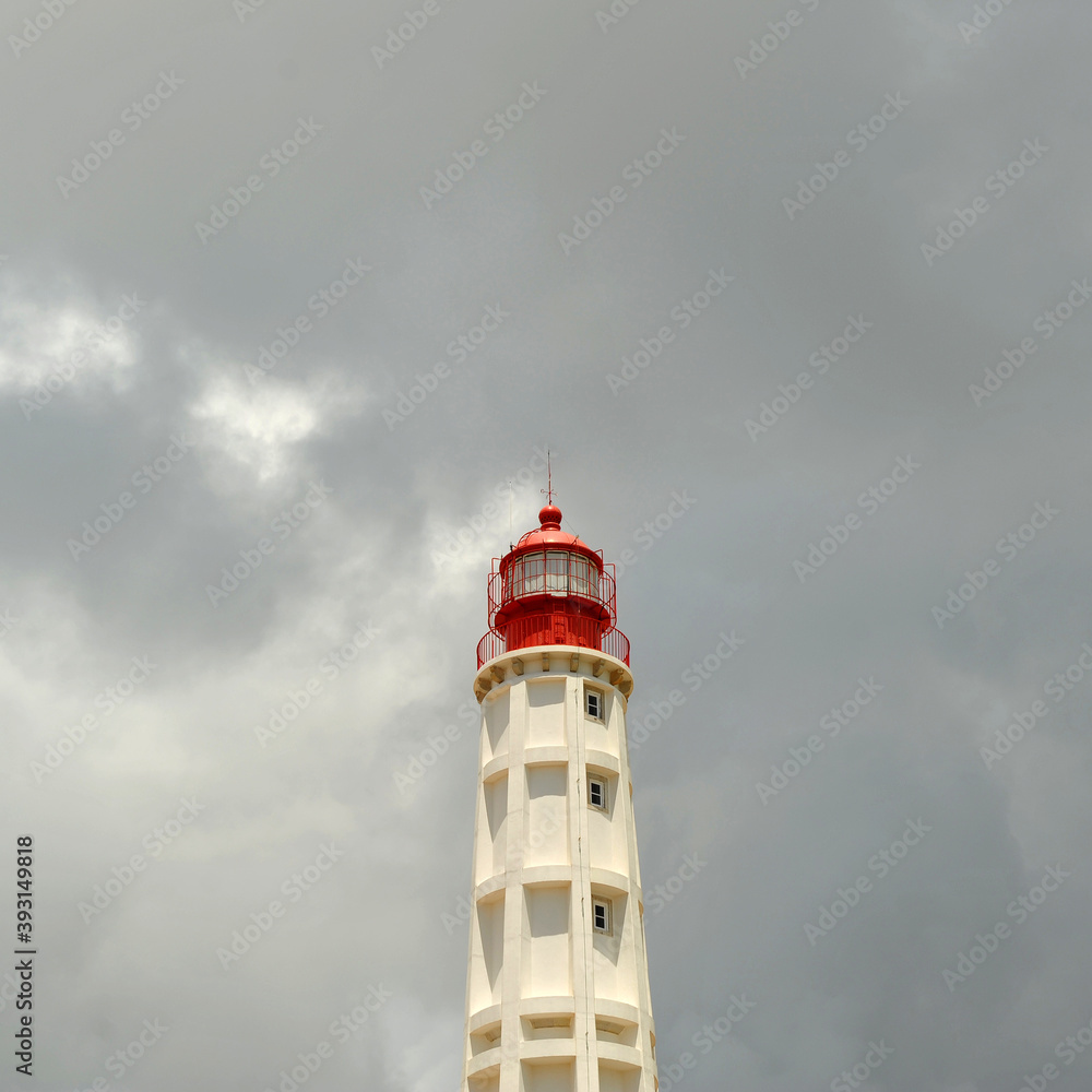 Lighthouse of Santa Maria on the island of Farol Culatra with a cloudy background. Natural Park of Ria Formosa, Algarve, south of Portugal