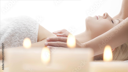 Young  beautiful and healthy woman in massaging salon. Traditional face massage therapy and skin care.