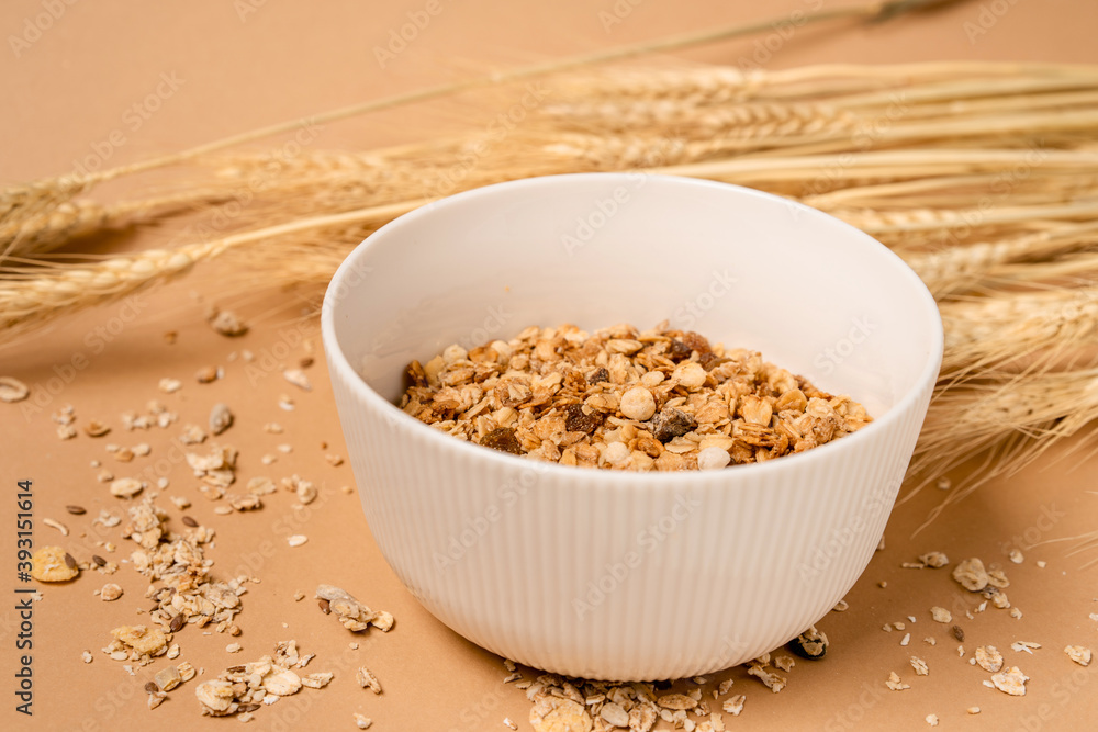 Deep bowl of cereal on a brown background. A healthy concept for breakfast, nearby are ears of wheat. copy space. Deep bowl of cereal on a brown background. A healthy concept for breakfast, nearby are ears of wheat. copy space.