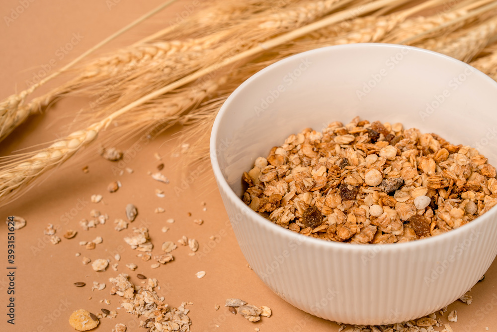 Deep bowl of cereal on a brown background. A healthy concept for breakfast, nearby are ears of wheat. copy space. Deep bowl of cereal on a brown background. A healthy concept for breakfast, nearby are ears of wheat. copy space.