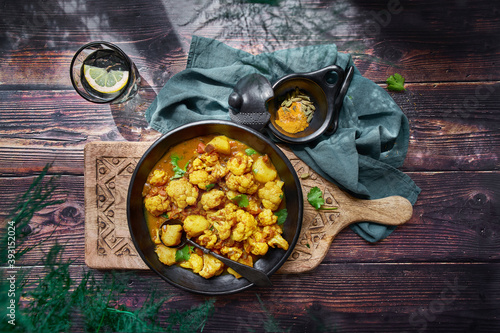 Top view of delicious cauliflower stew with turmeric and vegetables served on wooden table for dinner photo