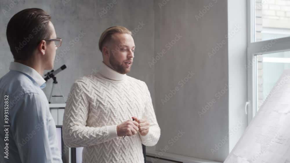 Architect and his colleague work in loft using drawing board. Workplace of young engineer in modern office. Real estate development. Architect and his colleague work in loft using drawing board. Workplace of young engineer in modern office. Real estate development.