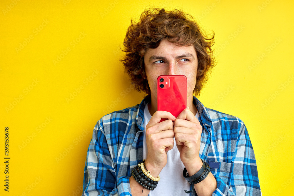 mysterious serious man use mobile phone isolated on yellow background, looking right , take photo mysterious serious man use mobile phone isolated on yellow background, looking right , take photo